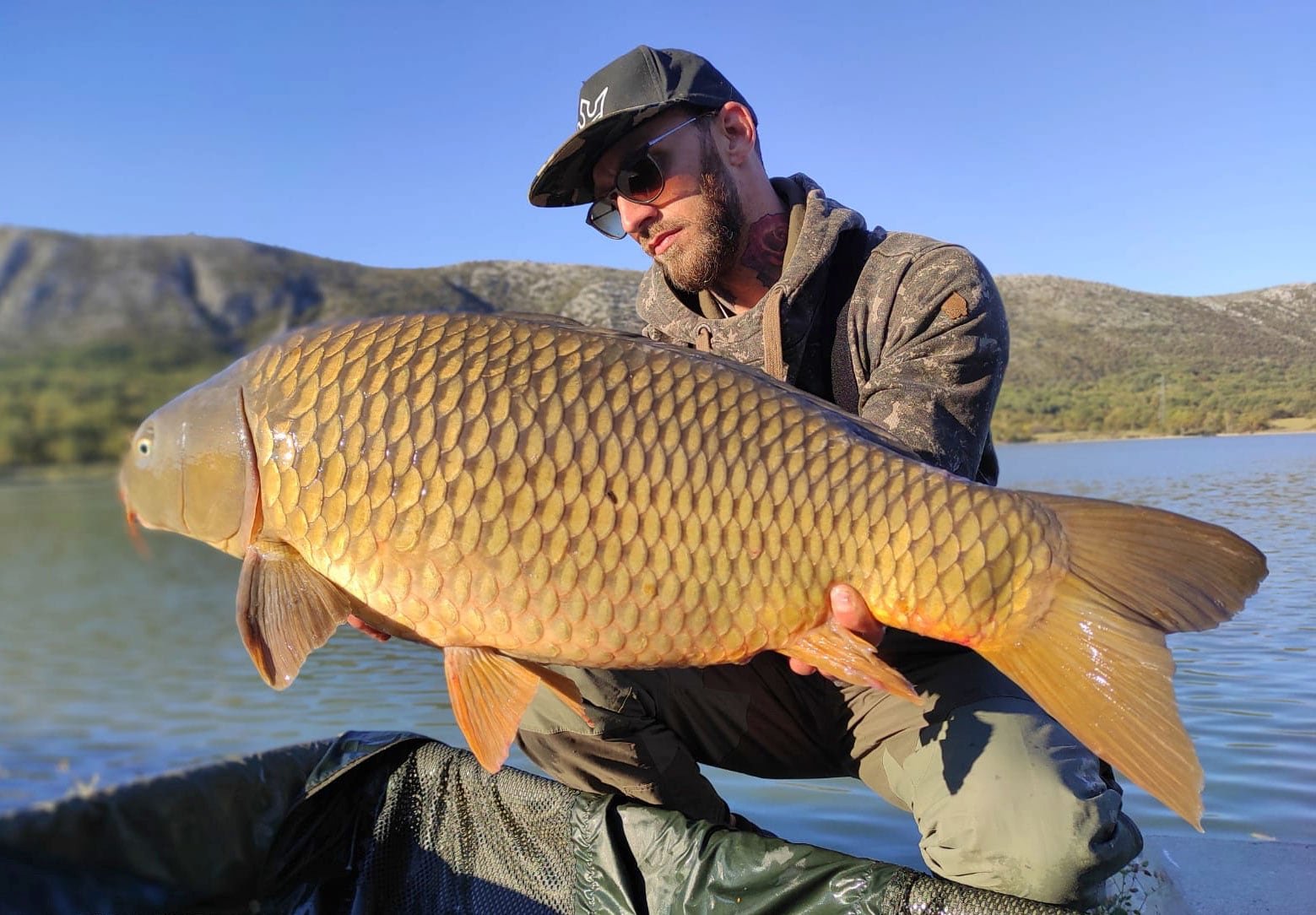 Angler holding carp caught on Tribalj lake in Croatia, Europe