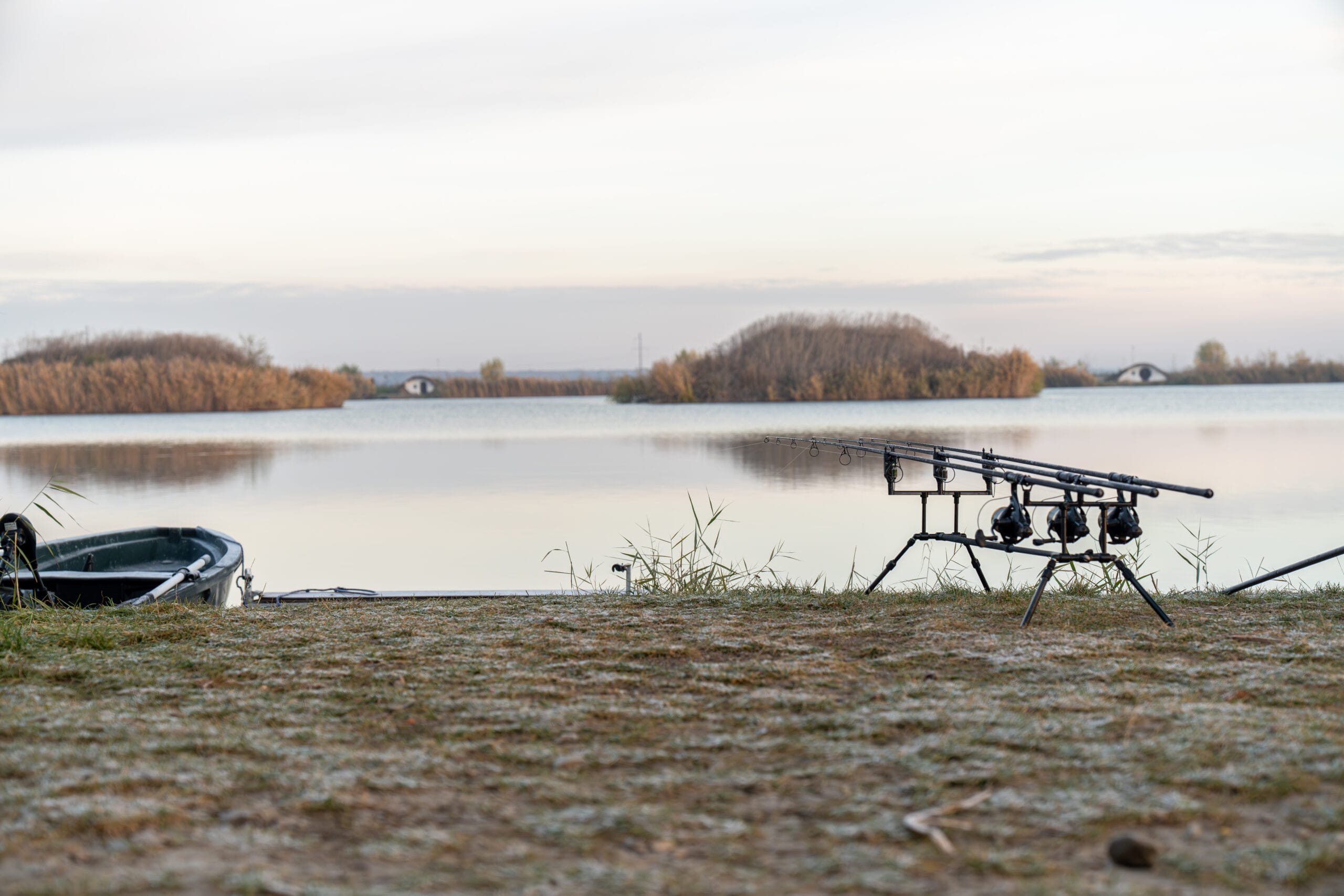 Fishing rods by a tranquil lake at dawn.