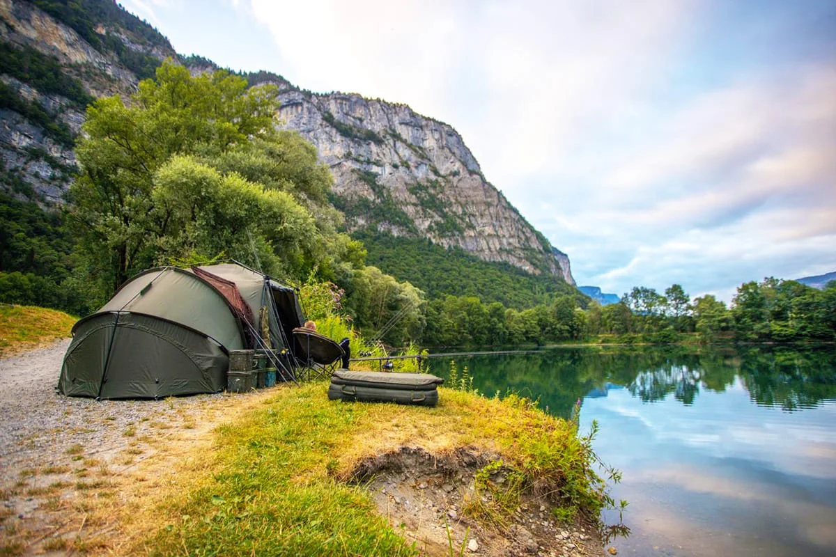 Tent by lake with mountain view.