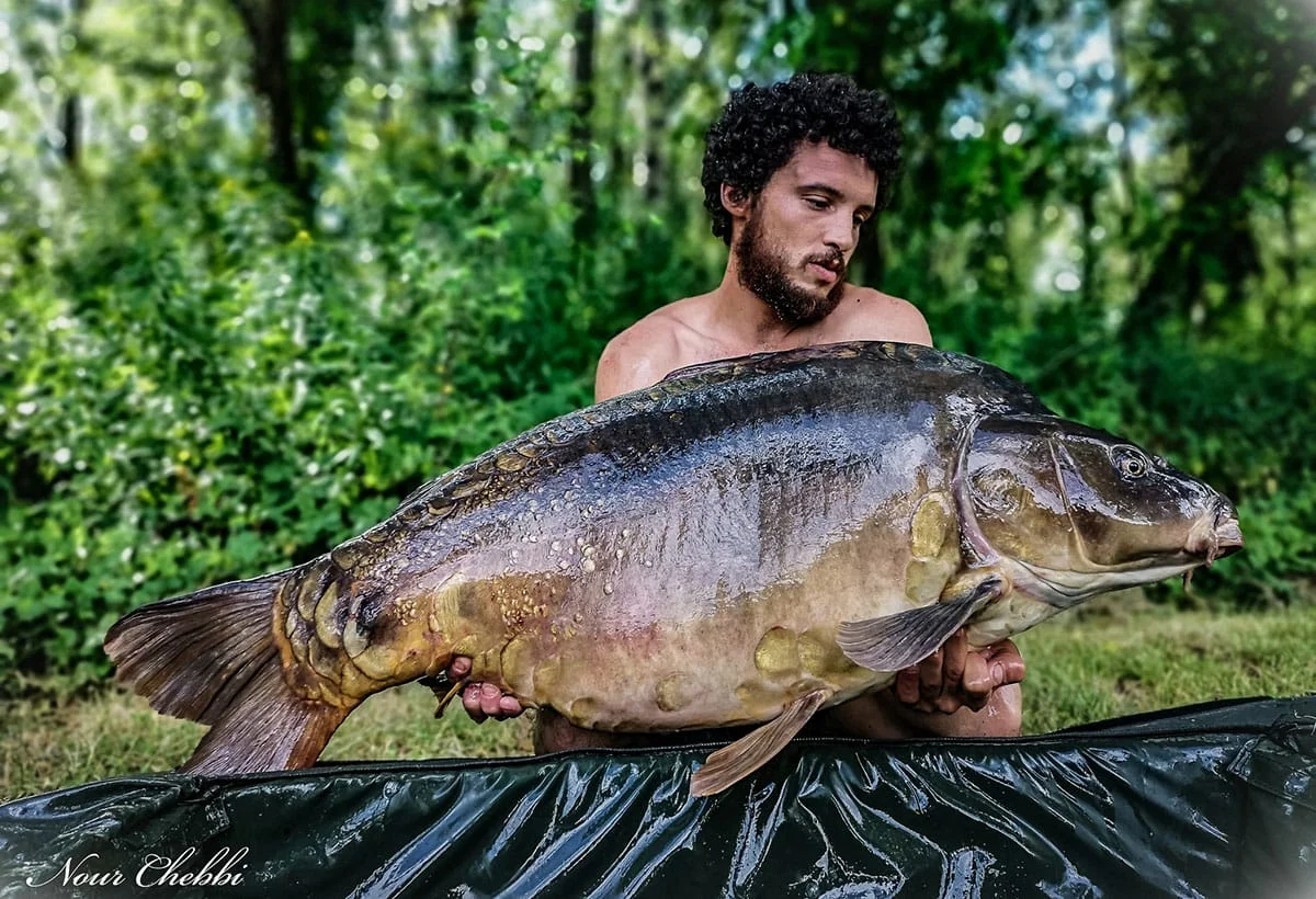 Man holding large fish outdoors