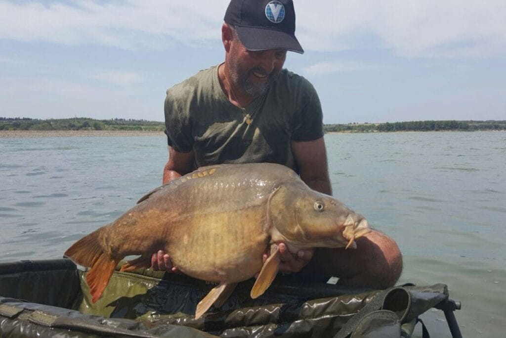 Man holding large fish by the lake