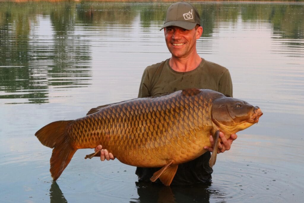 Man holding large carp in a lake