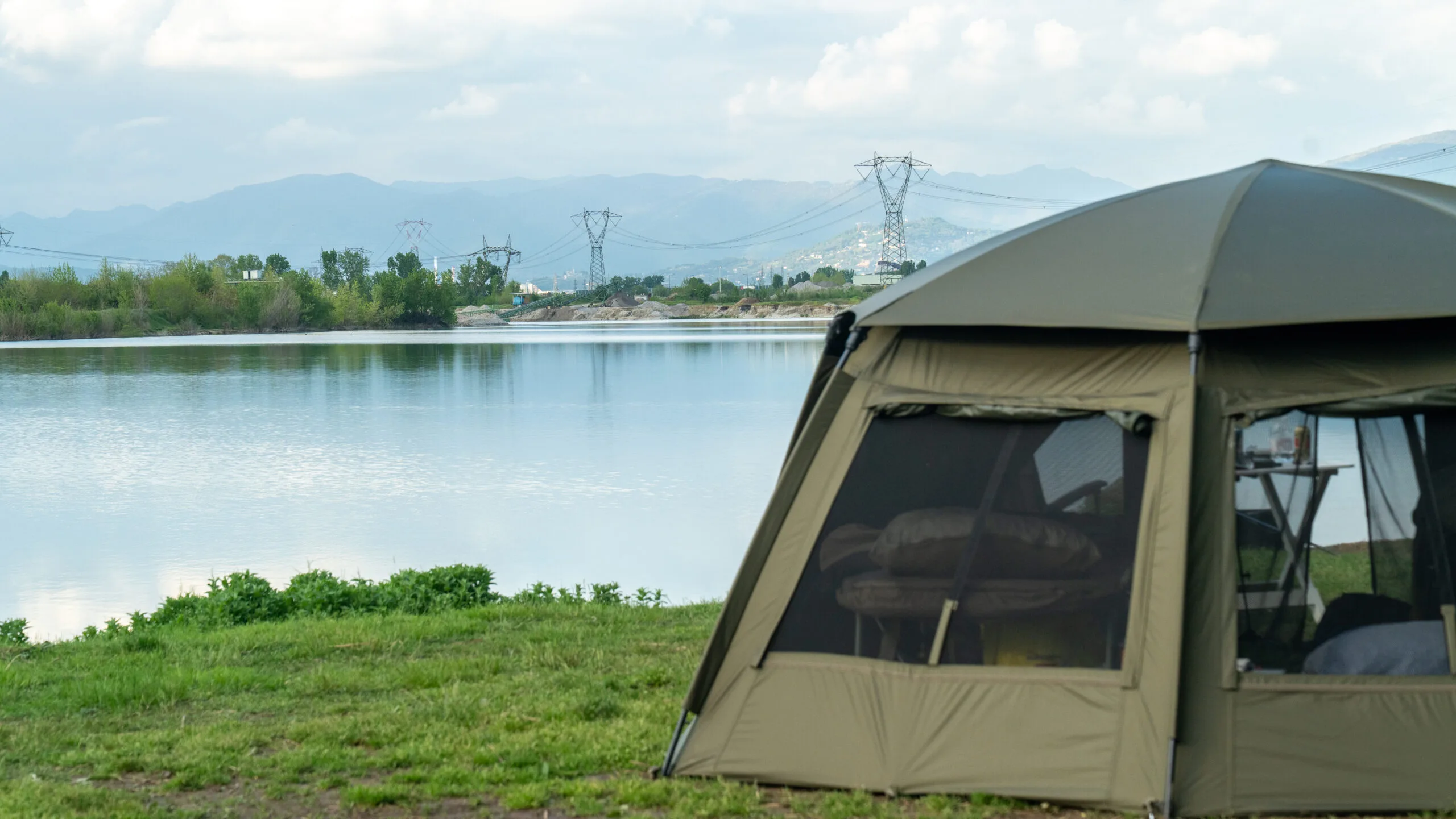Tent by lake with mountain view.